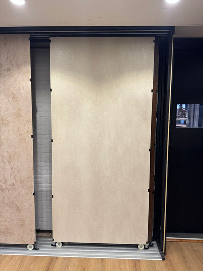 Beige betonlook SPC wandpaneel in showroom opstelling met grote plaat en strakke afwerking